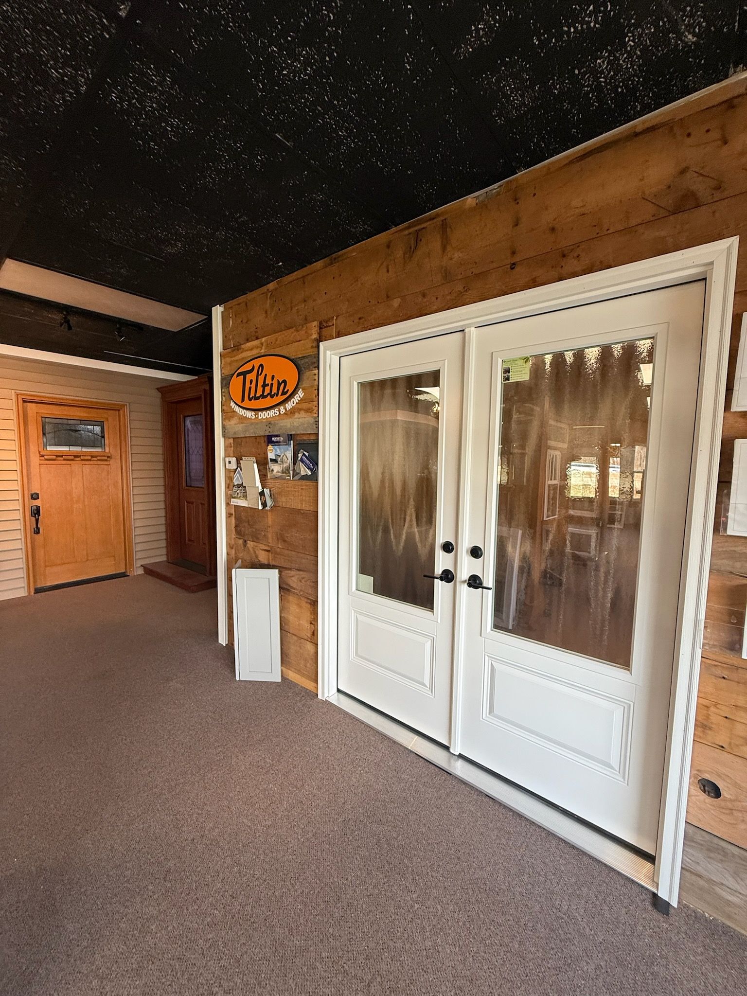 Indoor hallway with white double doors, wood-paneled walls, and a starry black ceiling