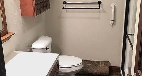Bathroom with a toilet, sink, shower, and towel rack.