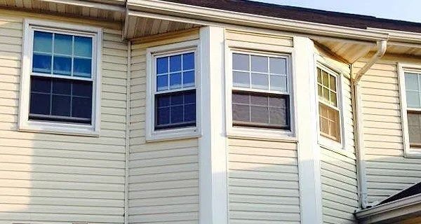 Beige siding on a house with white-framed windows; some windows are open.