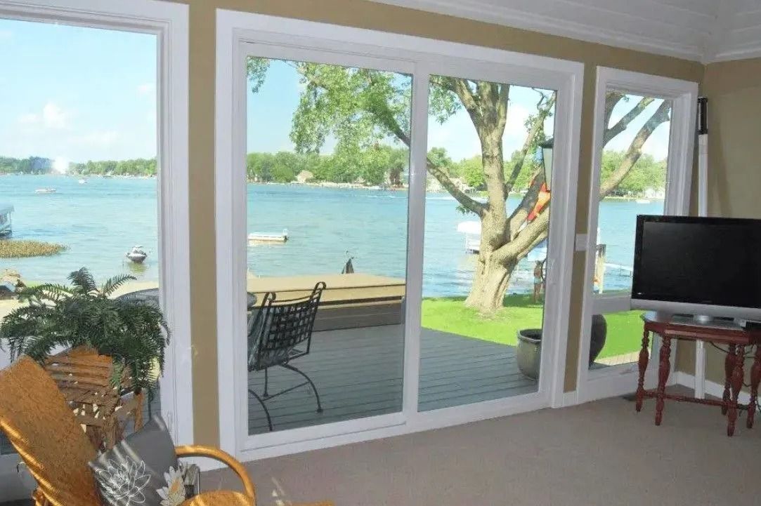 Interior view of a living room with large windows overlooking a lake.