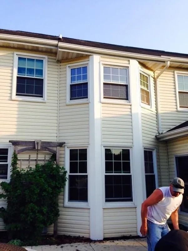 Beige building with multiple windows; a person carries something near the structure.