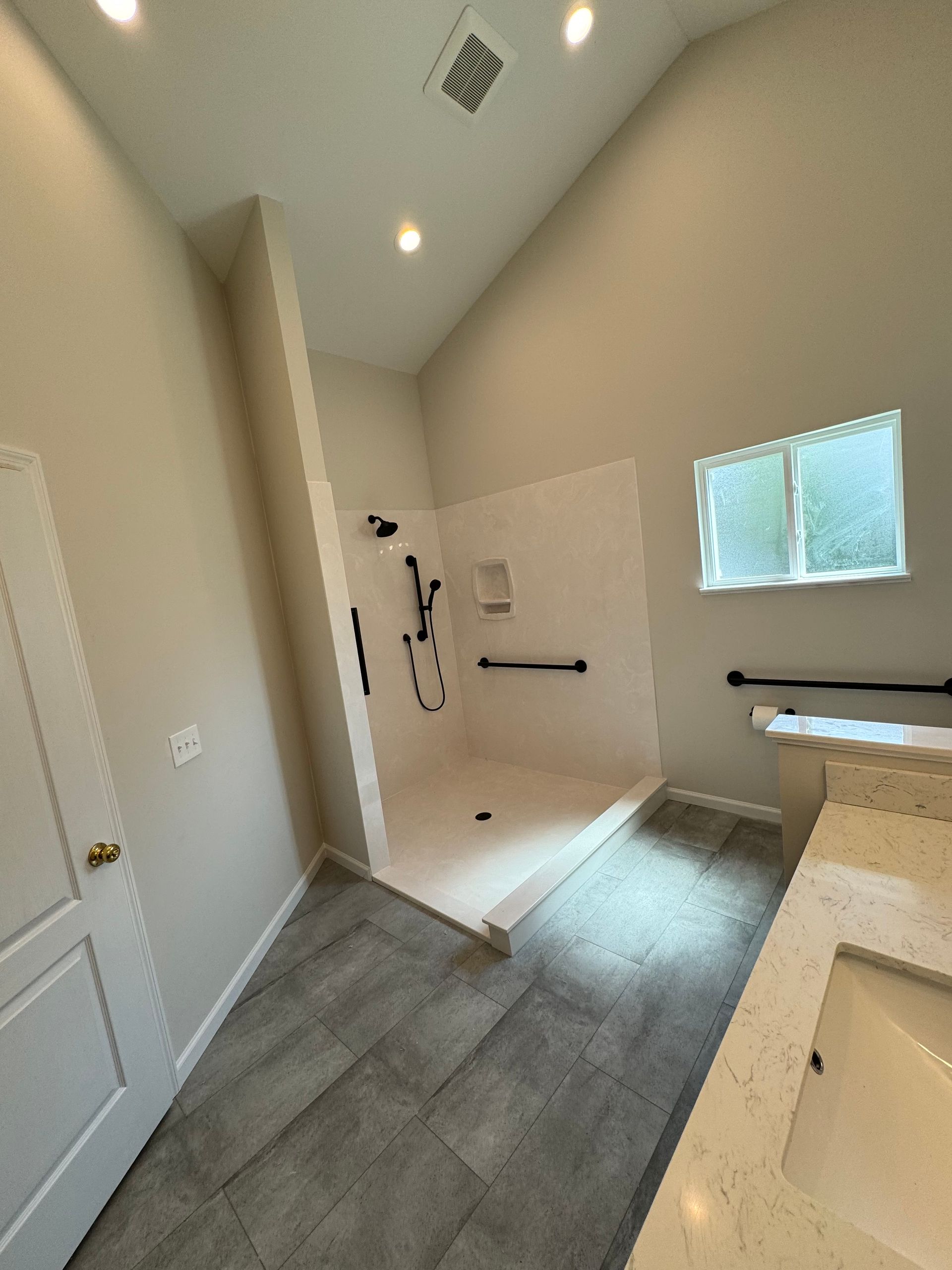 A bathroom with a sink and a walk in shower