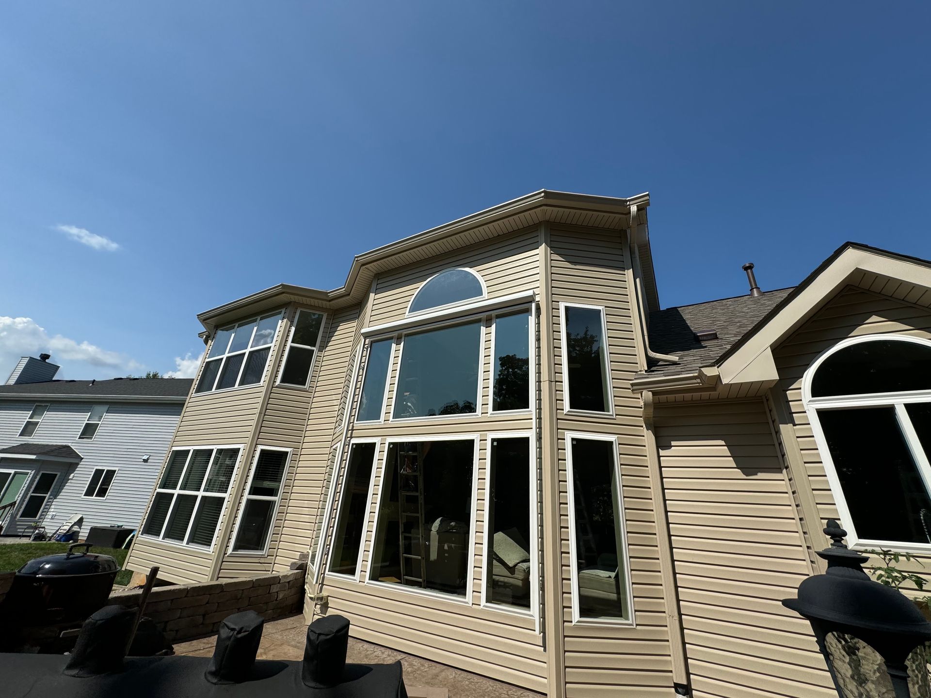 A house with a lot of windows and a blue sky in the background