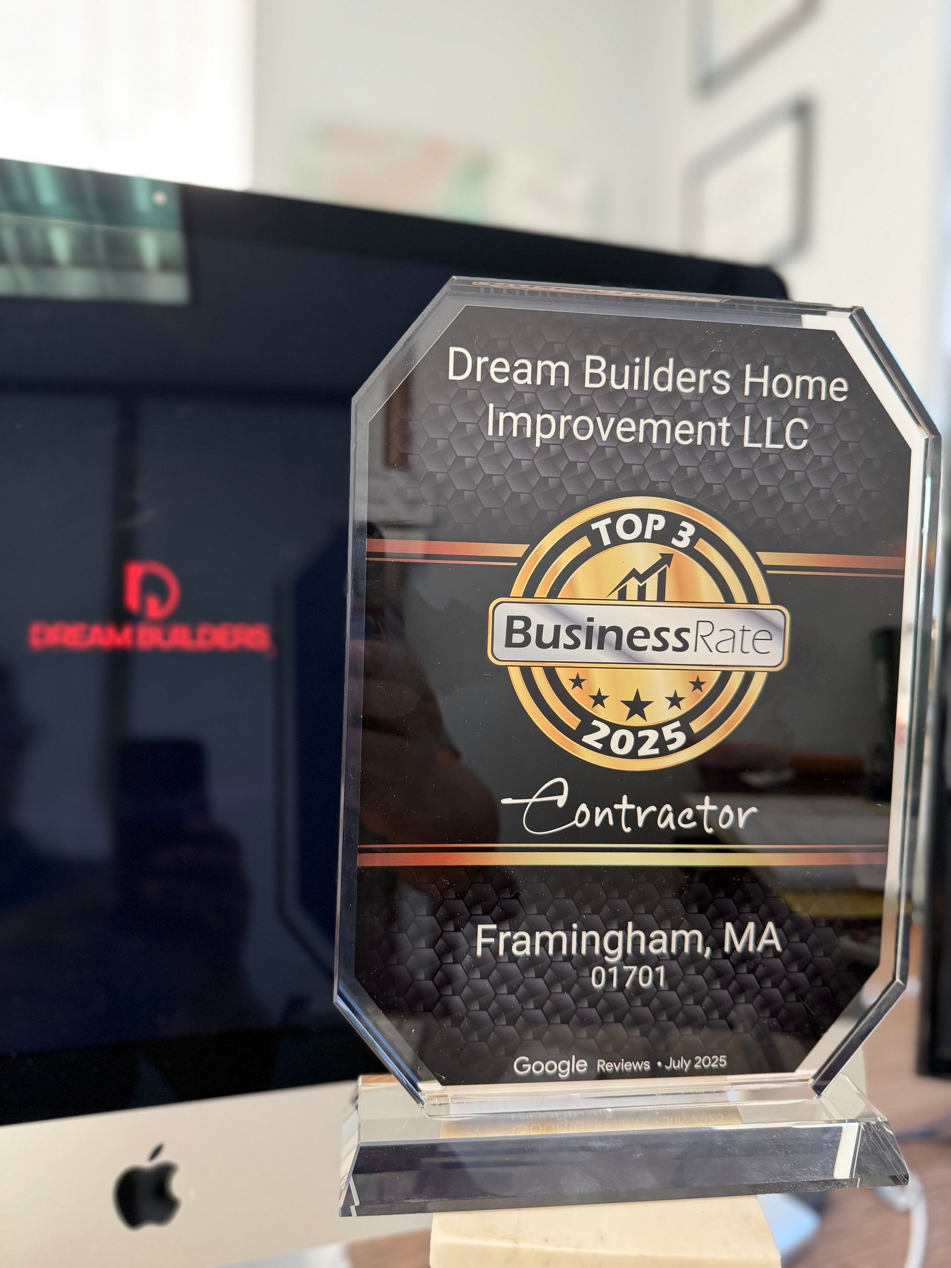Award for Dream Builders Home Improvement LLC, Top 1 Business, 2025 Contractor, Framingham, MA. Computer monitor in the background.