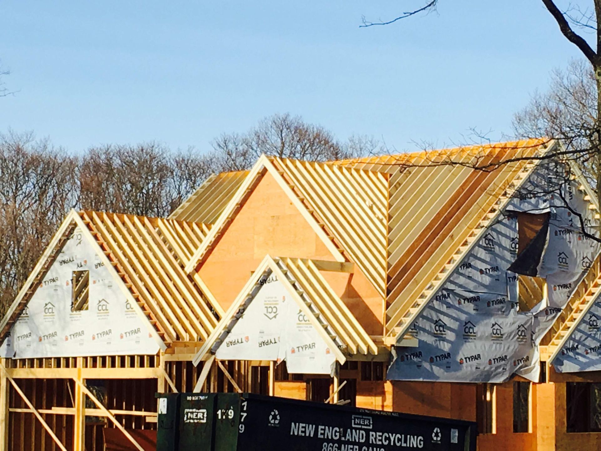 House under construction; wooden frame and roof rafters visible.