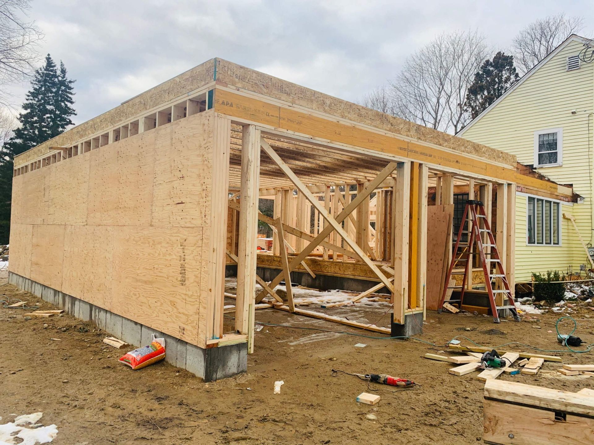 Garage construction: Wooden frame with OSB sheathing on concrete foundation.