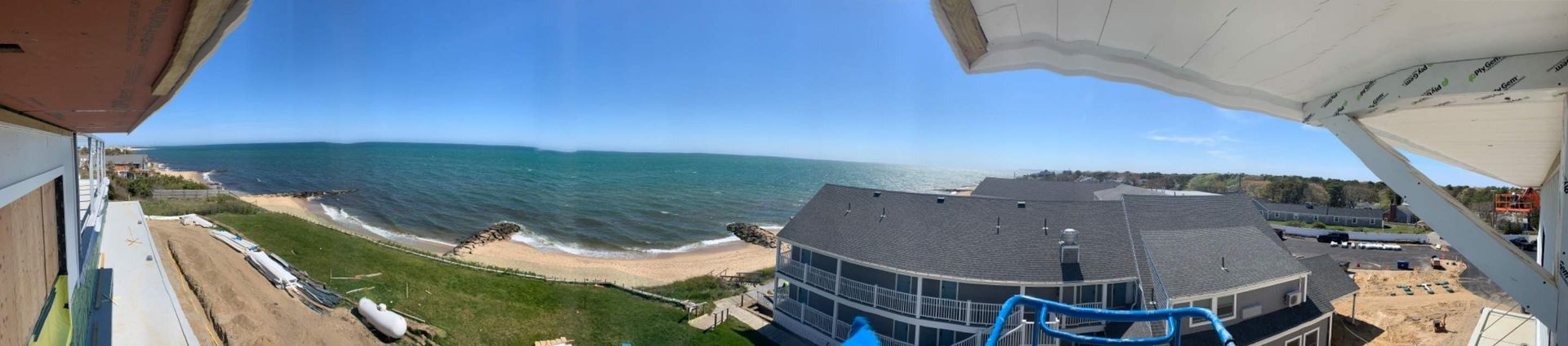 Panoramic view of a beach, ocean, and building on a sunny day.