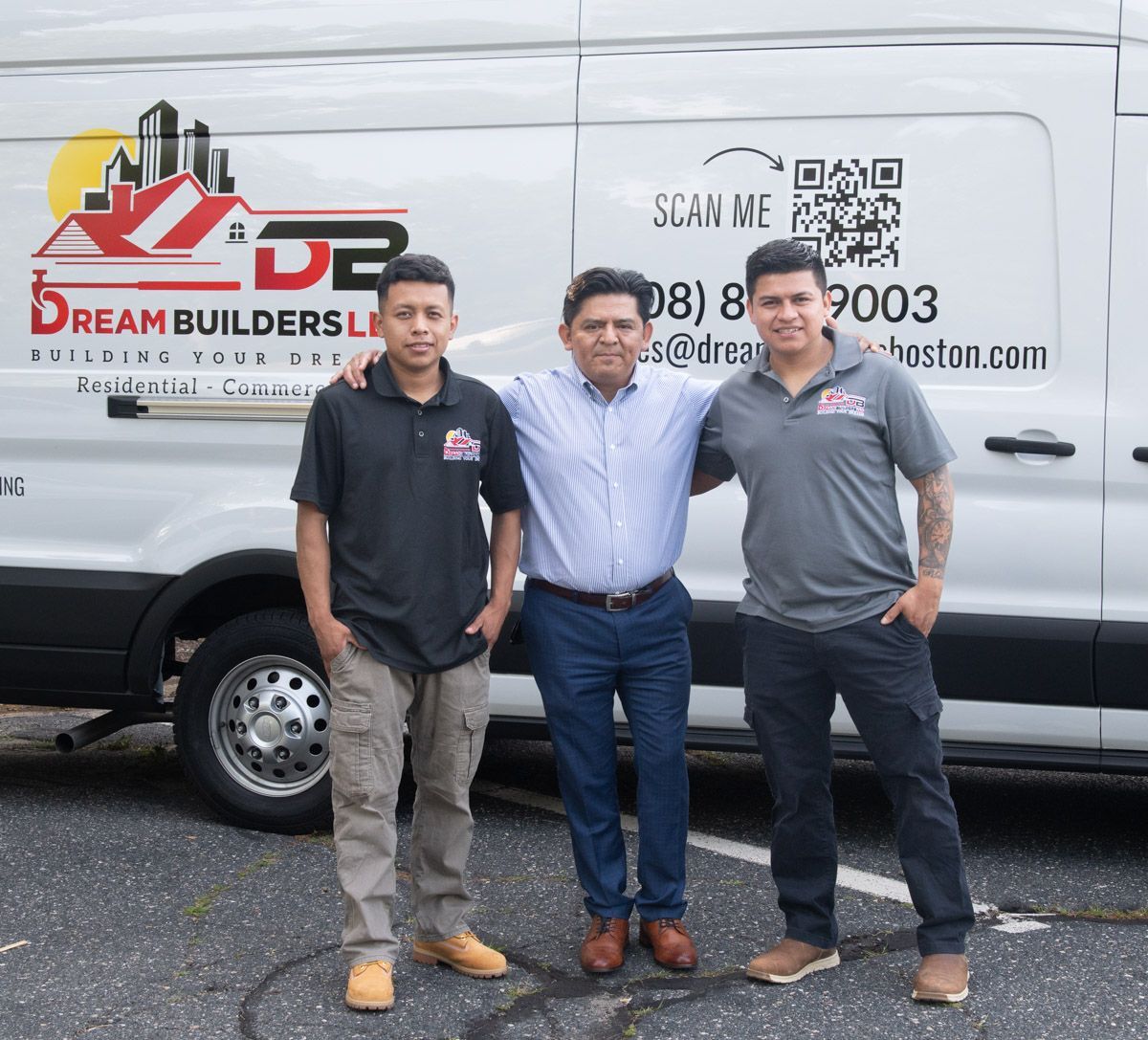 Three men stand in front of a van with a company logo. They are smiling, arms around each other.