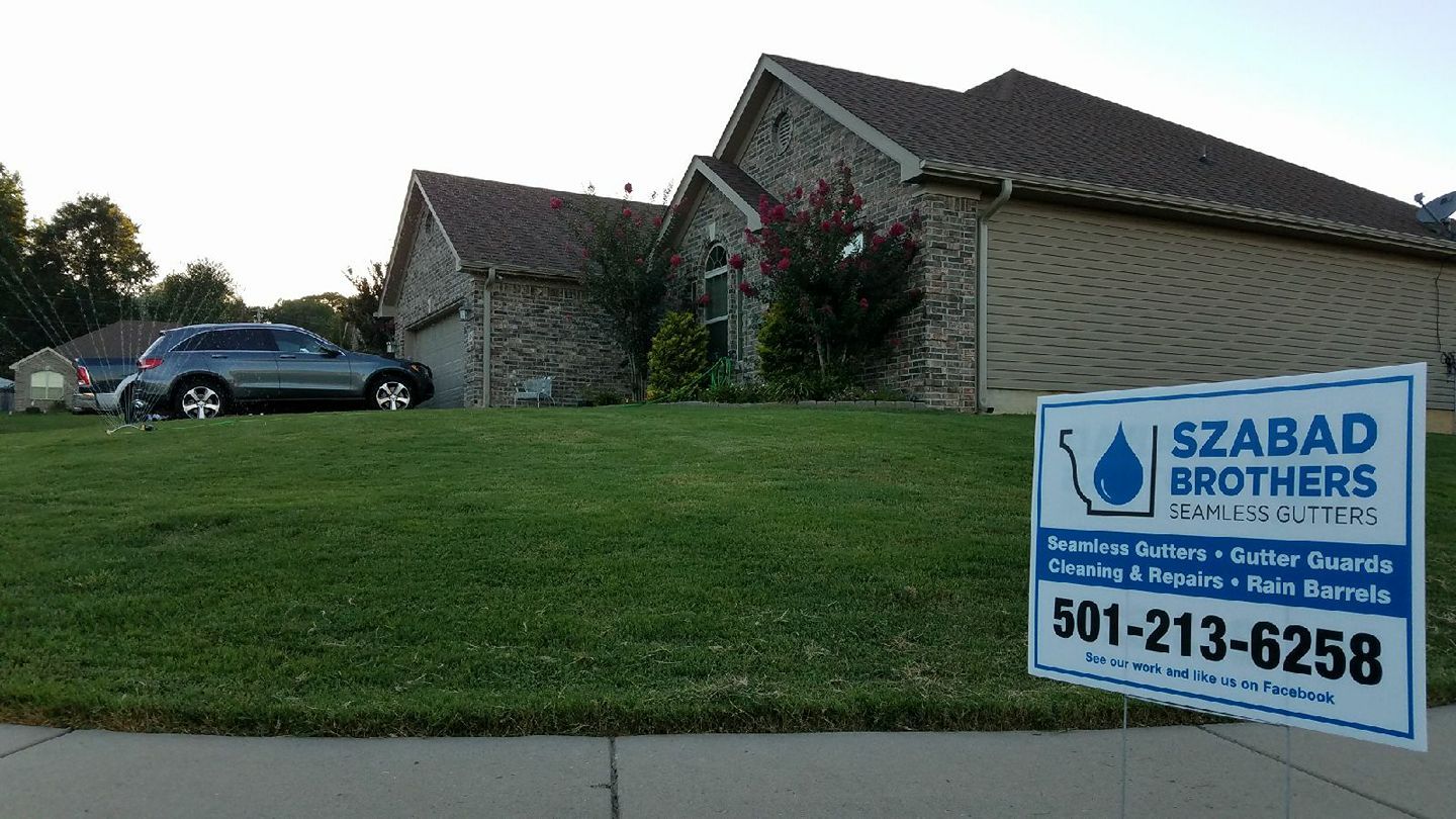 A sign for szabad brothers is in front of a house