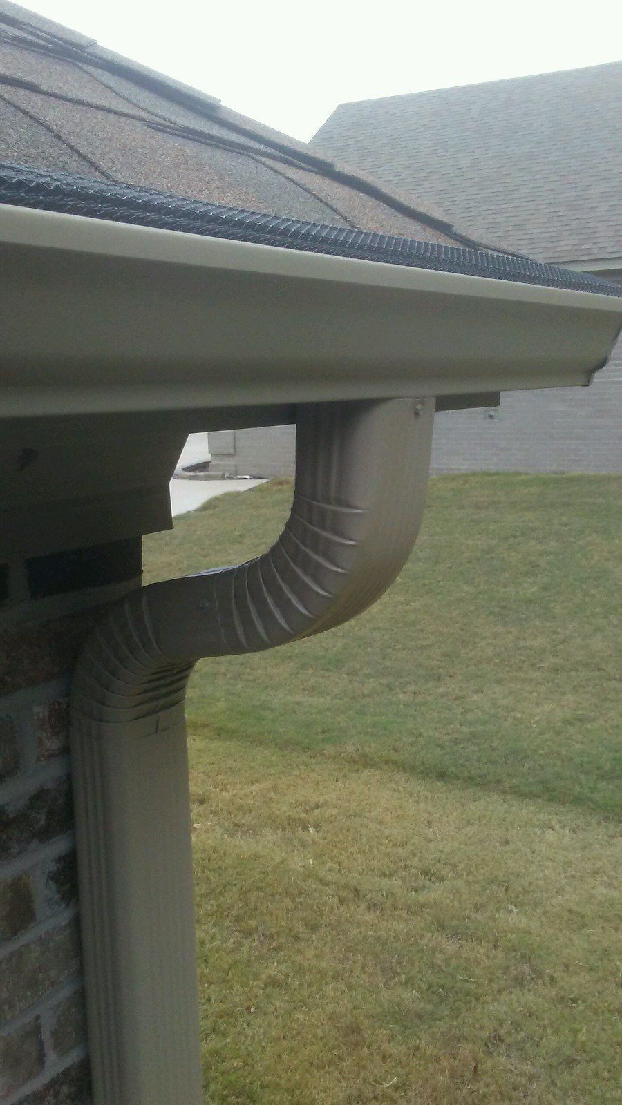 A close up of a gutter on the side of a house.
