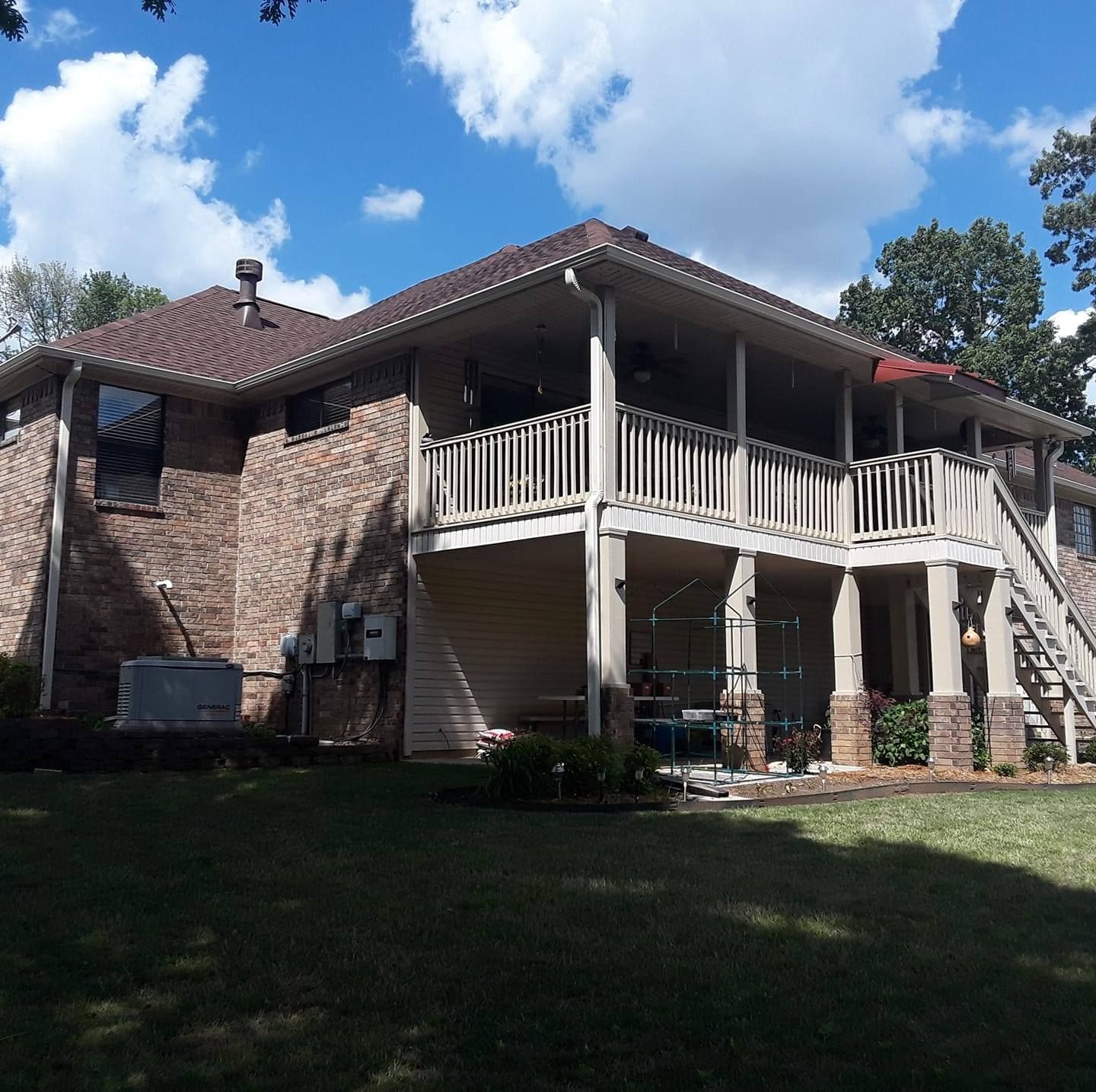 A brick house with a large deck and stairs