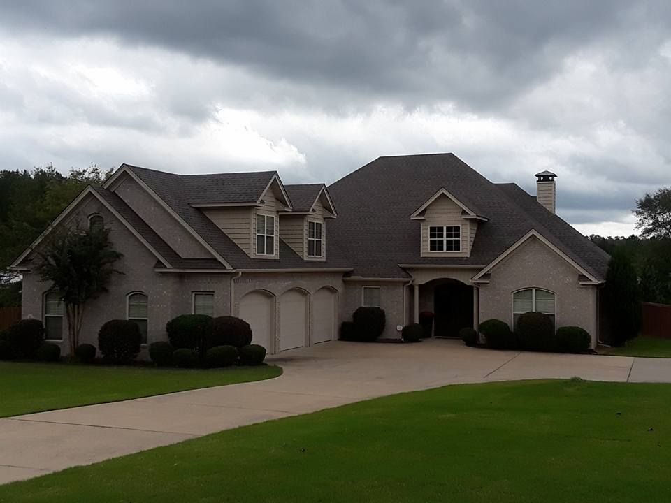 A large house with a gray roof and a driveway