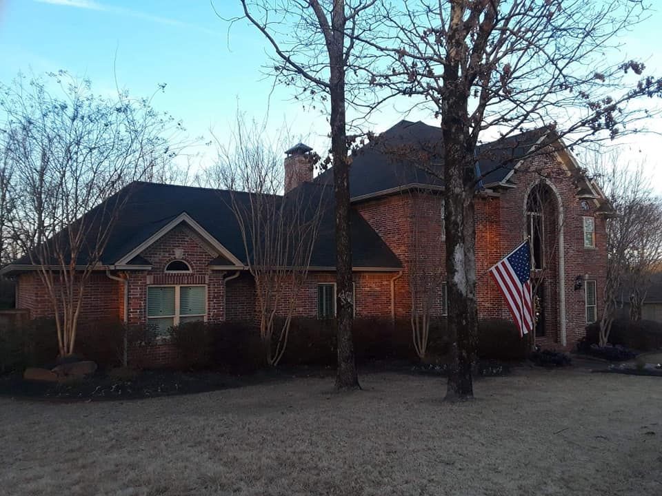 A large brick house with an american flag in front of it