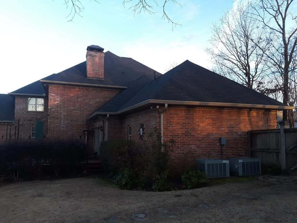 A large brick house with a black roof
