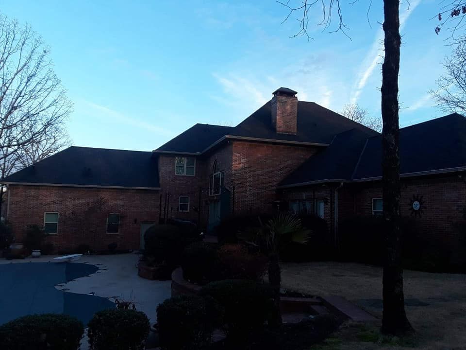 A large brick house with a pool in front of it