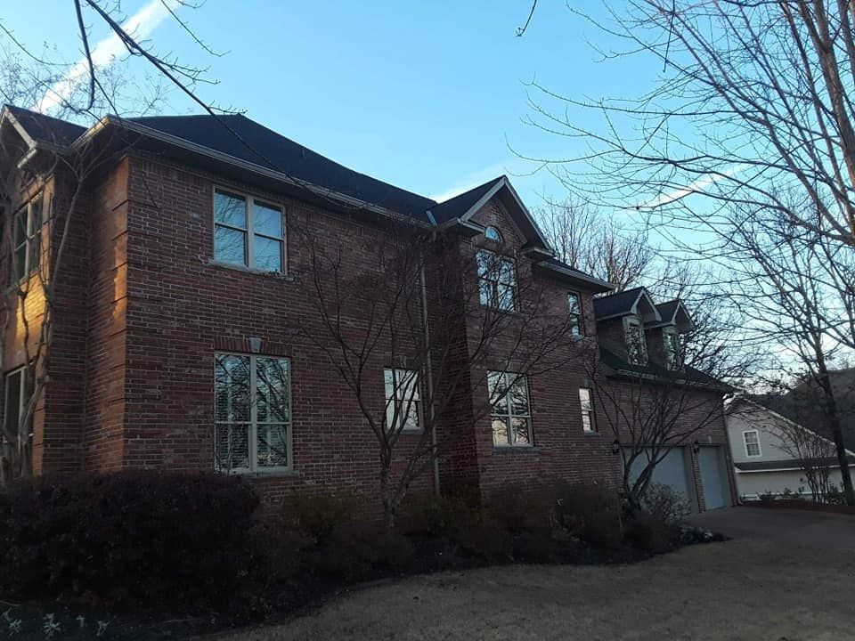 A large brick house with a black roof