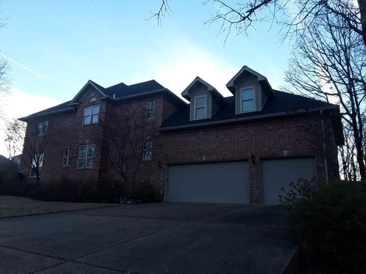 A large brick house with two white garage doors