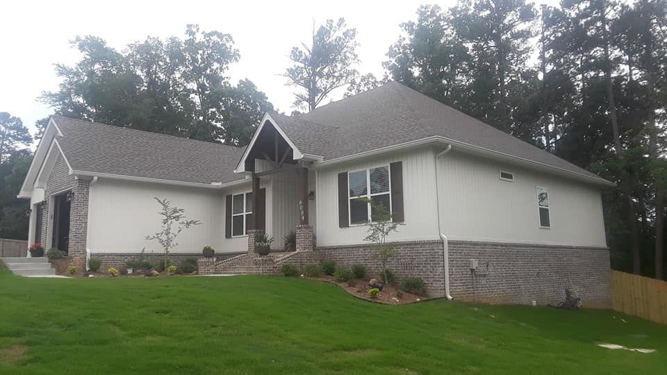 A white house with a gray roof and black shutters