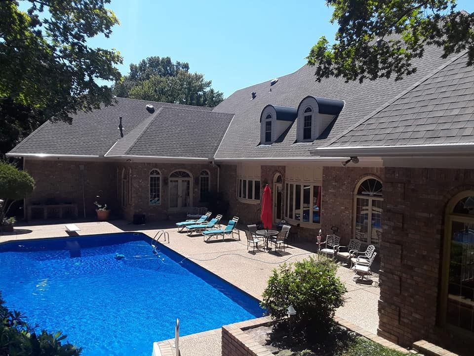 A large house with a large swimming pool in front of it