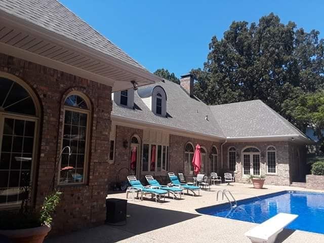 A large house with a swimming pool in front of it