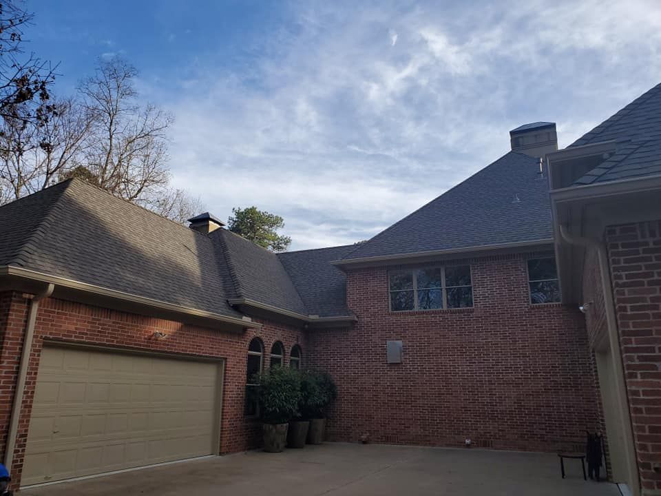 A large brick house with a garage and a roof.