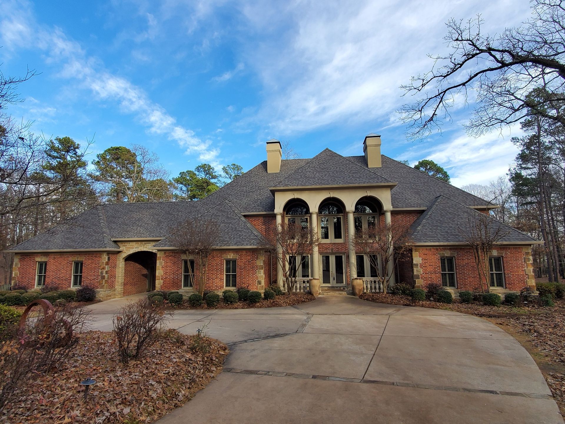 A large brick house with a driveway leading to it