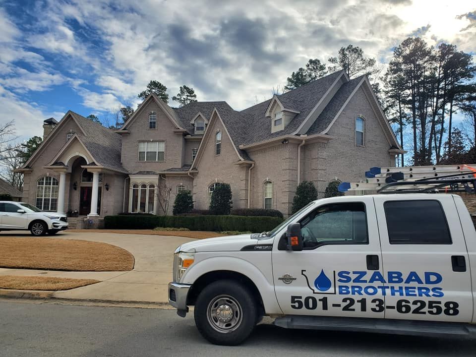A white truck is parked in front of a large house.
