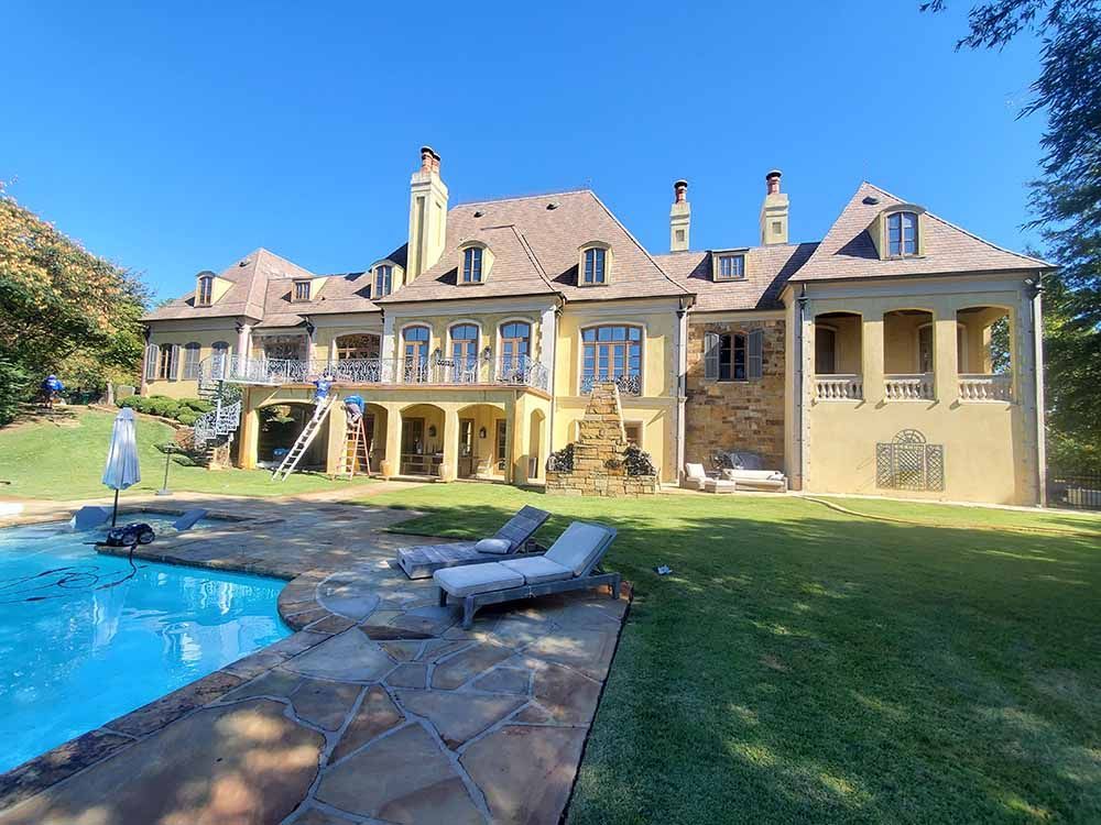 A large house with a swimming pool in front of it.