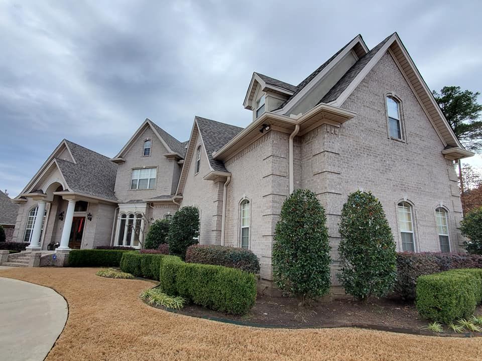 A large white brick house with a gray roof