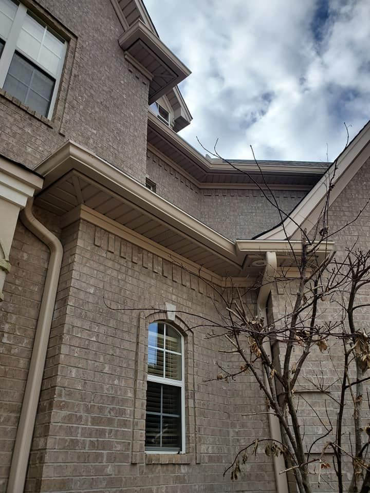 A large brick house with a tree in front of it.