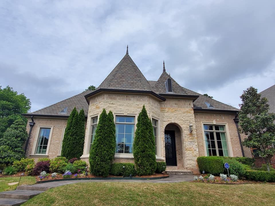 A large brick house with a roof that looks like a castle.