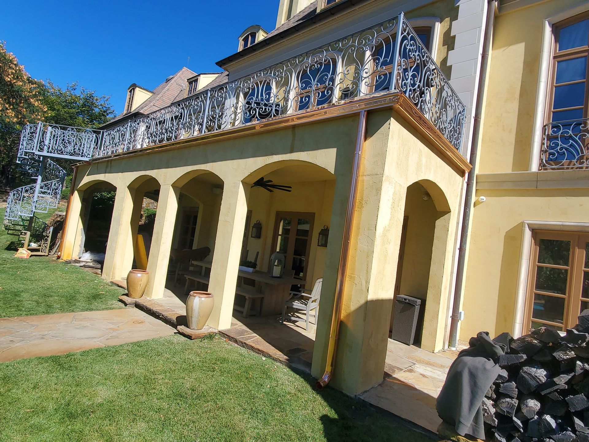A large yellow building with arches and a balcony