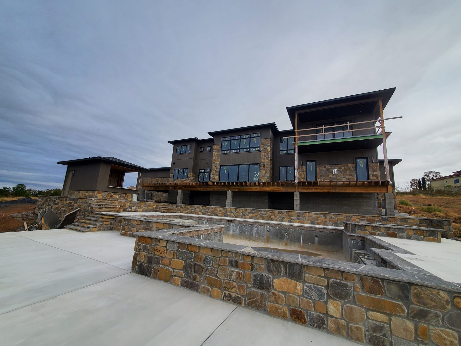 A large house with a pool in front of it is being built.
