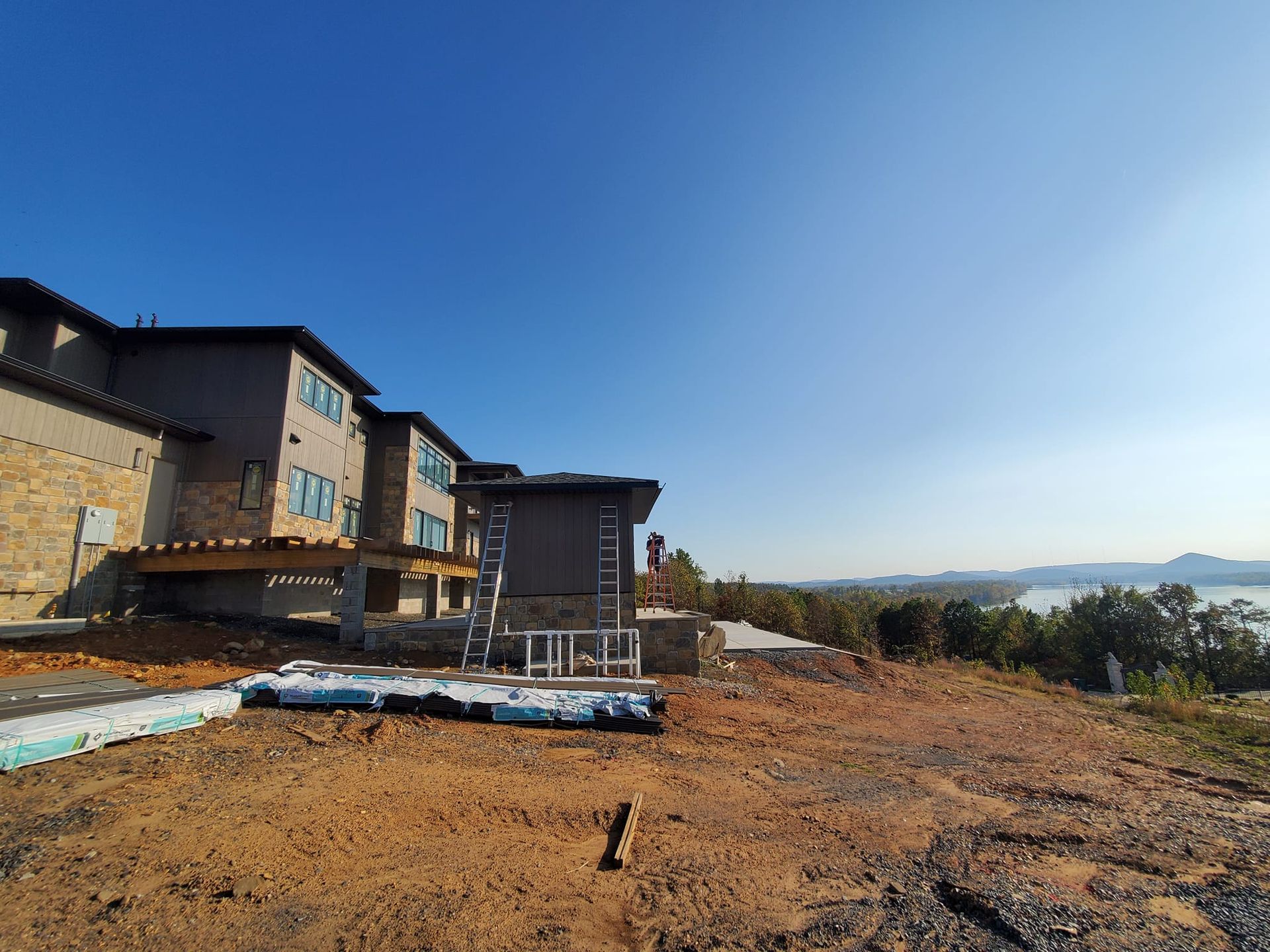 A large building is being built on top of a dirt hill.