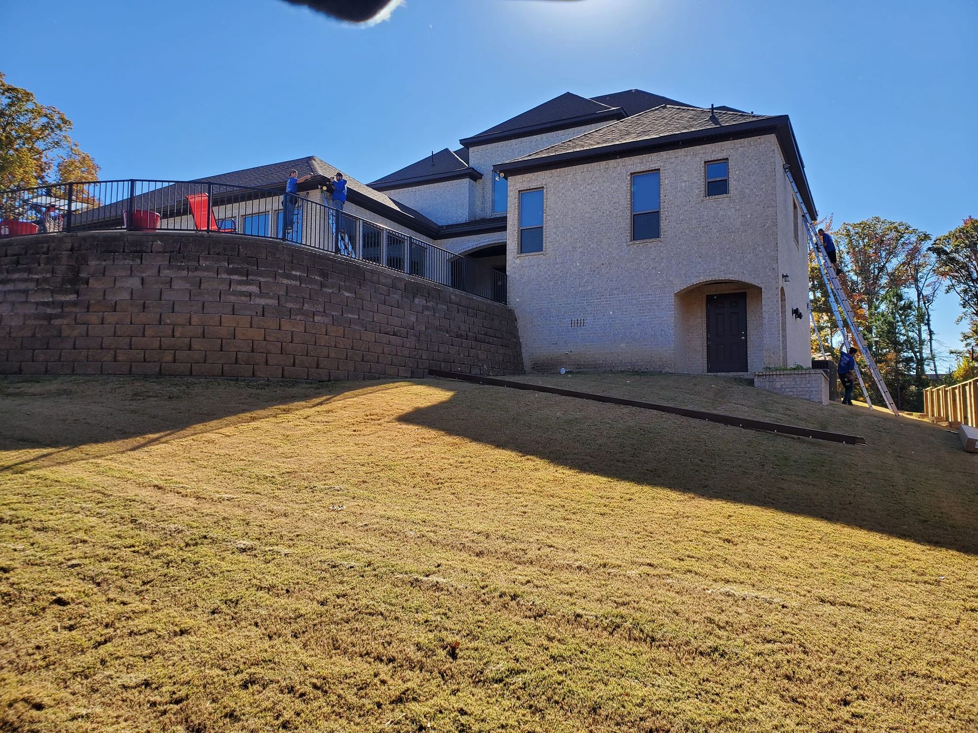 A large house is sitting on top of a grassy hill.