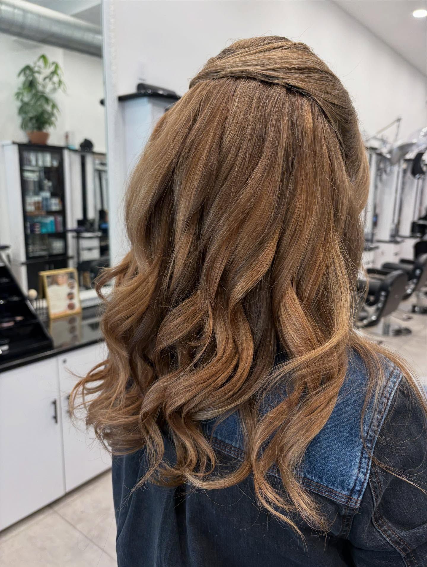 Long wavy brown hair with a half-up braid, seen from behind in a salon chair