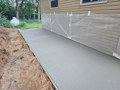 A concrete walkway is being built in front of a house.