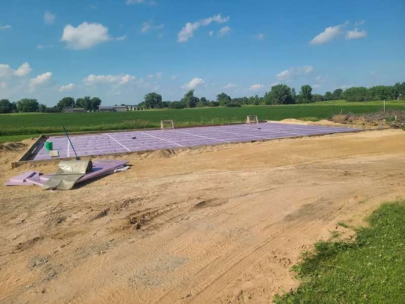 A construction site with a lot of purple foam on the ground.