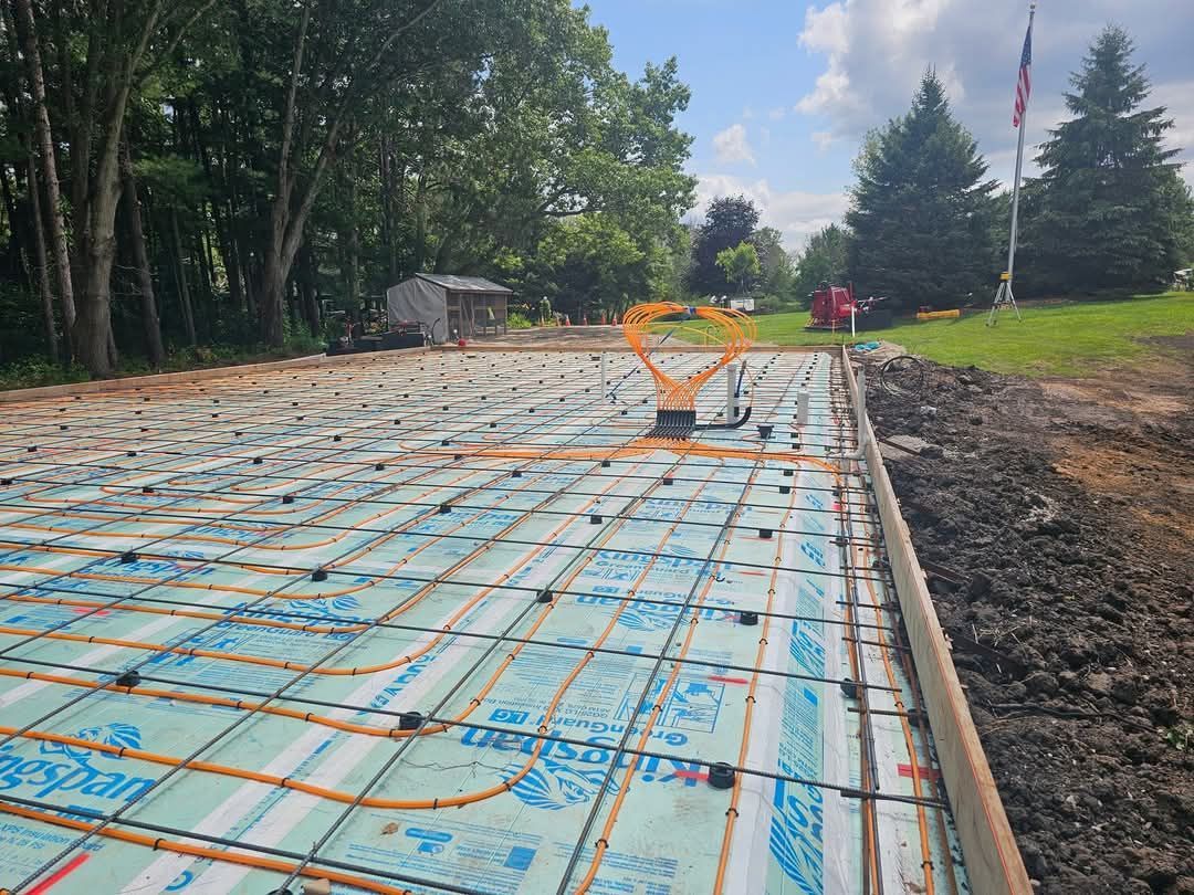 A concrete foundation is being built in a yard with a flag in the background.