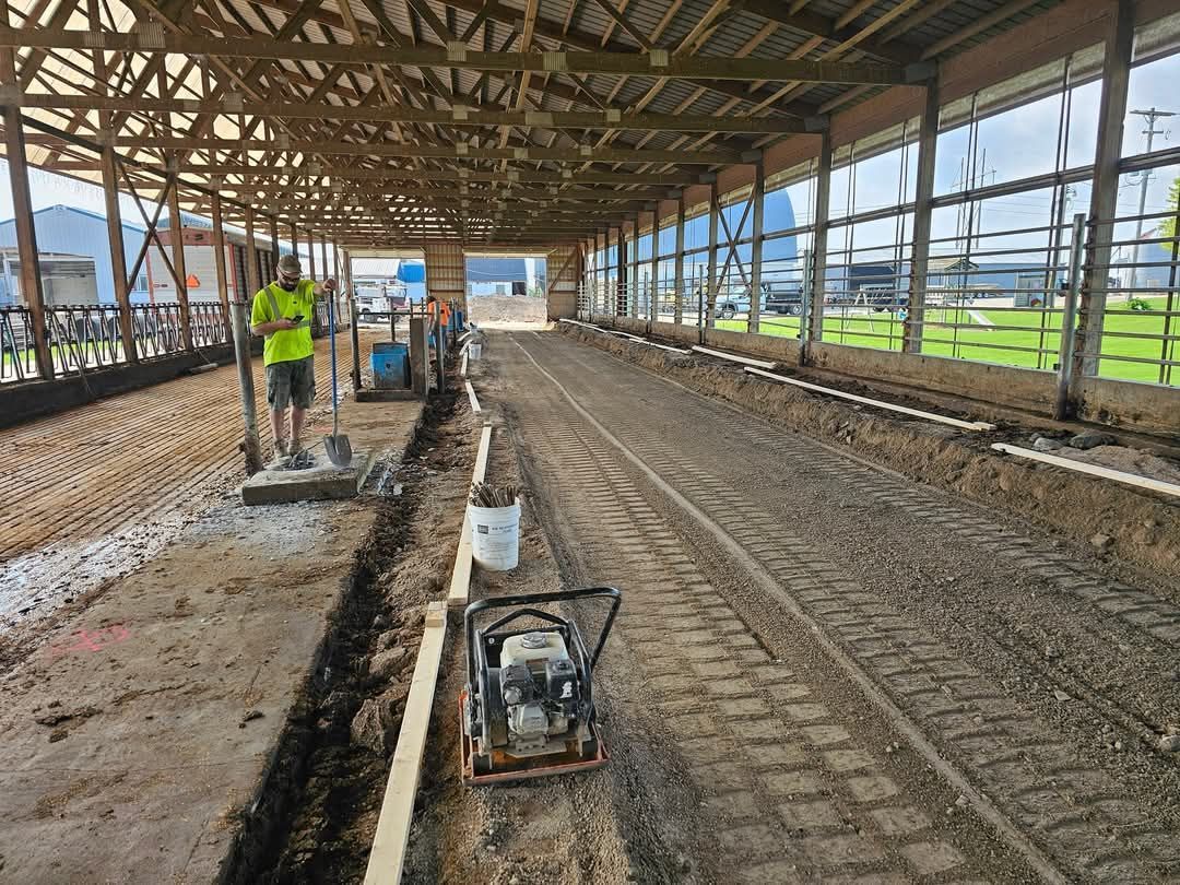 A man is standing in the dirt inside of a building.