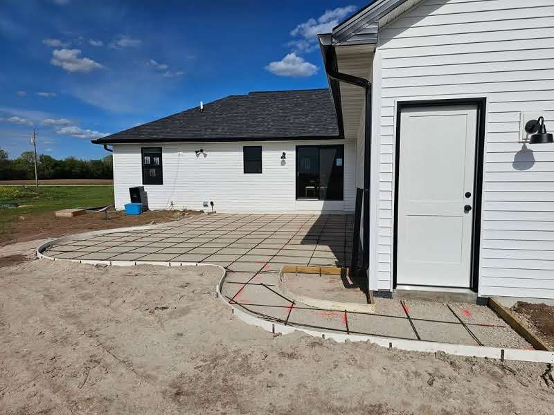 A white house with a concrete patio in front of it.