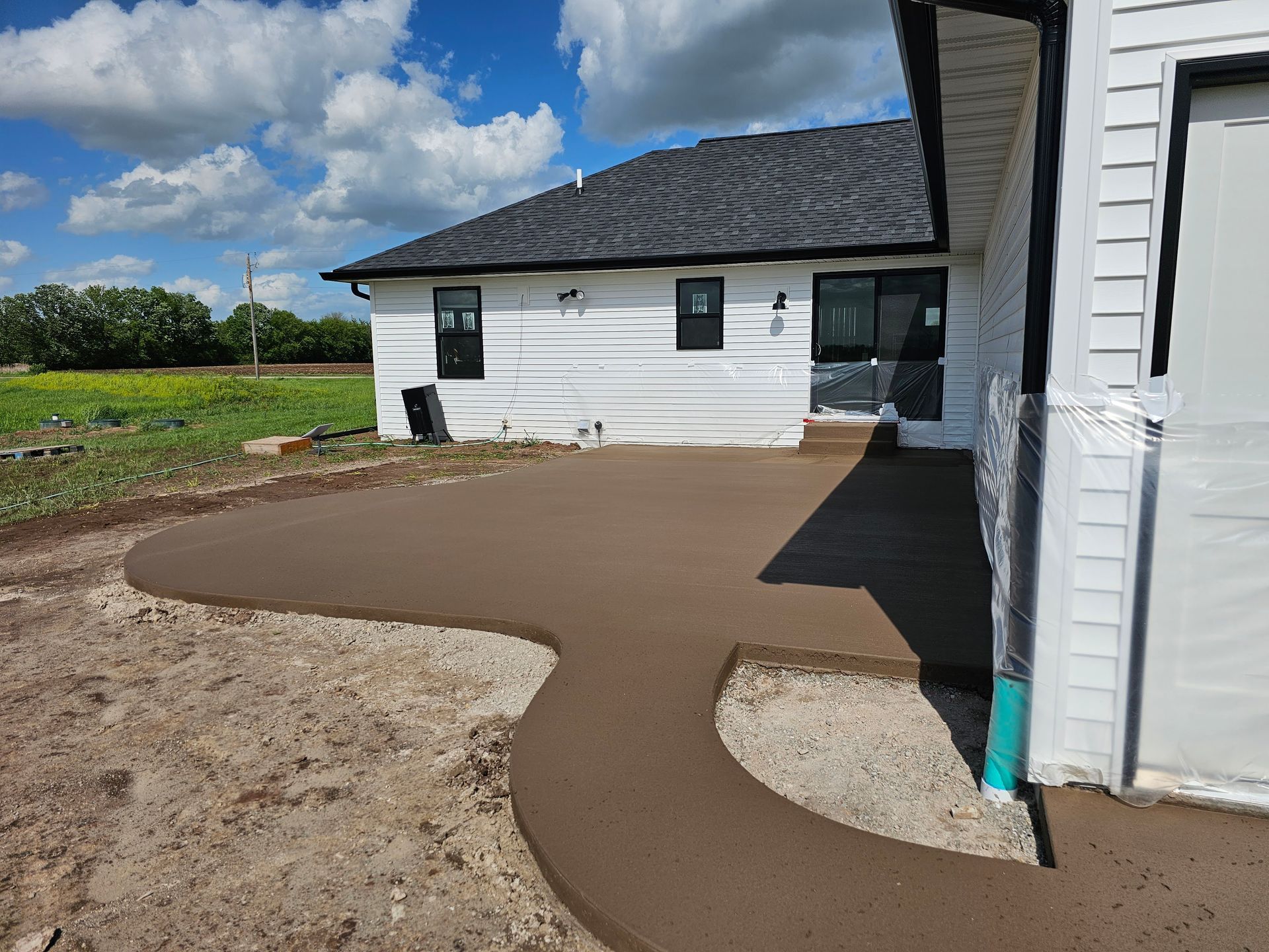 A white house with a concrete walkway in front of it.