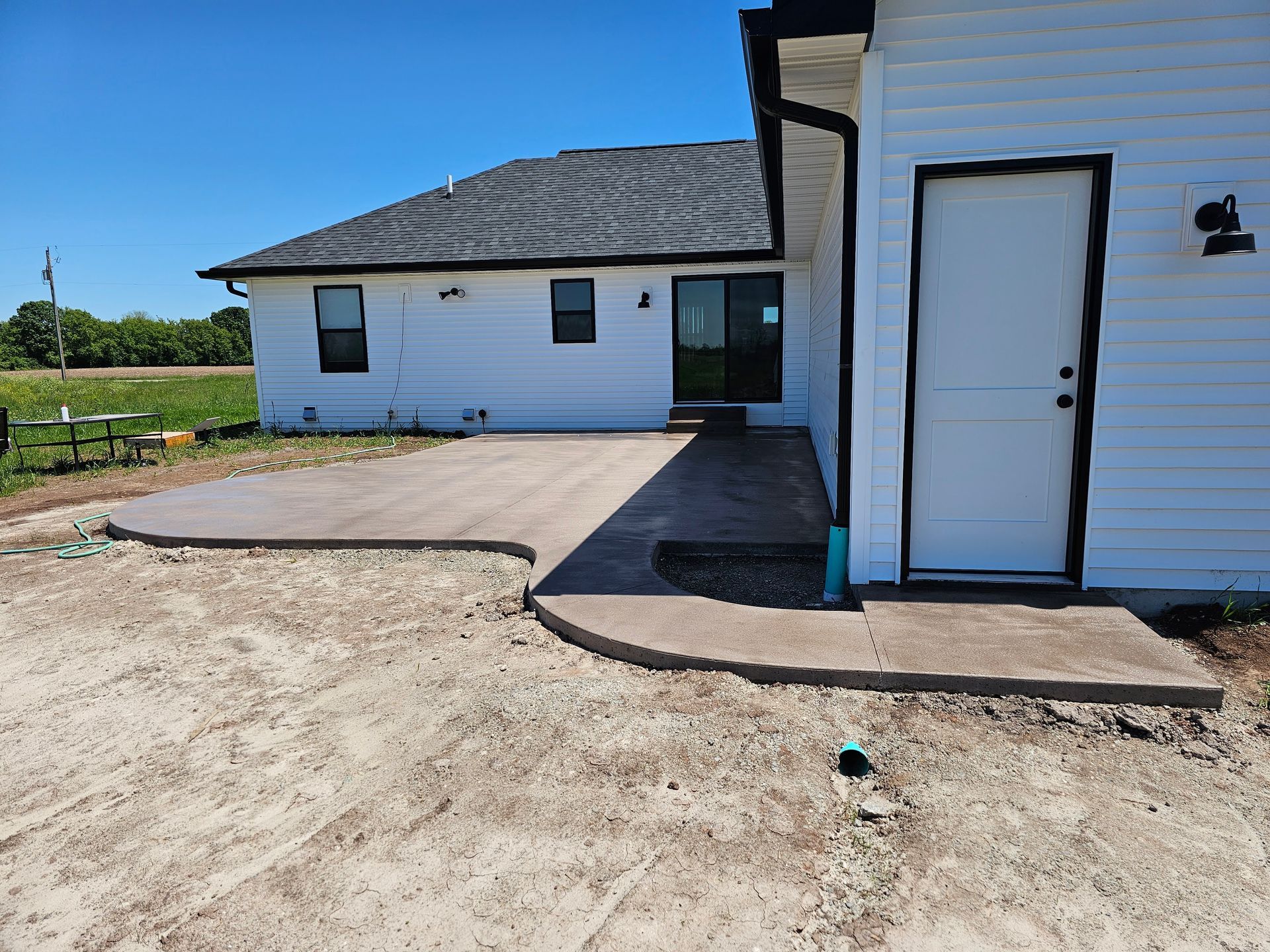 A white house with a concrete driveway in front of it.