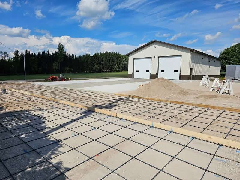 A concrete driveway is being built in front of a garage.