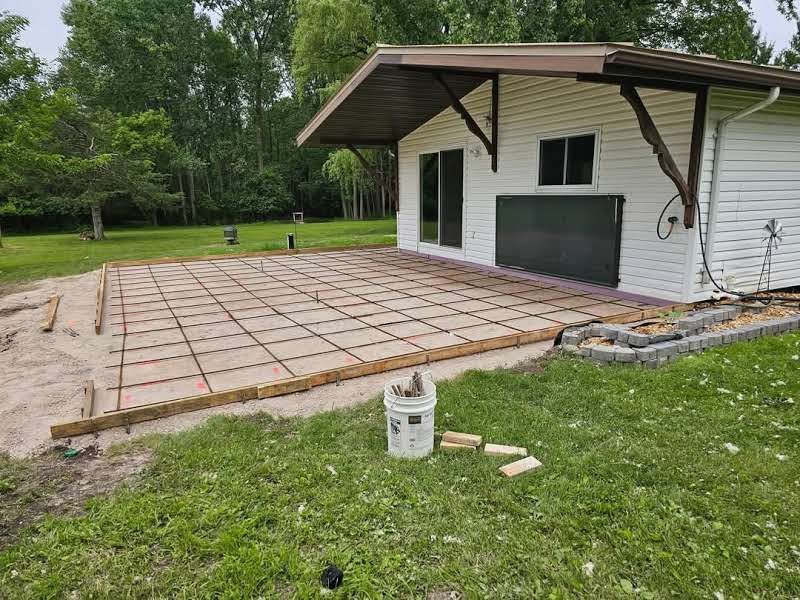 A concrete driveway is being built in front of a house.