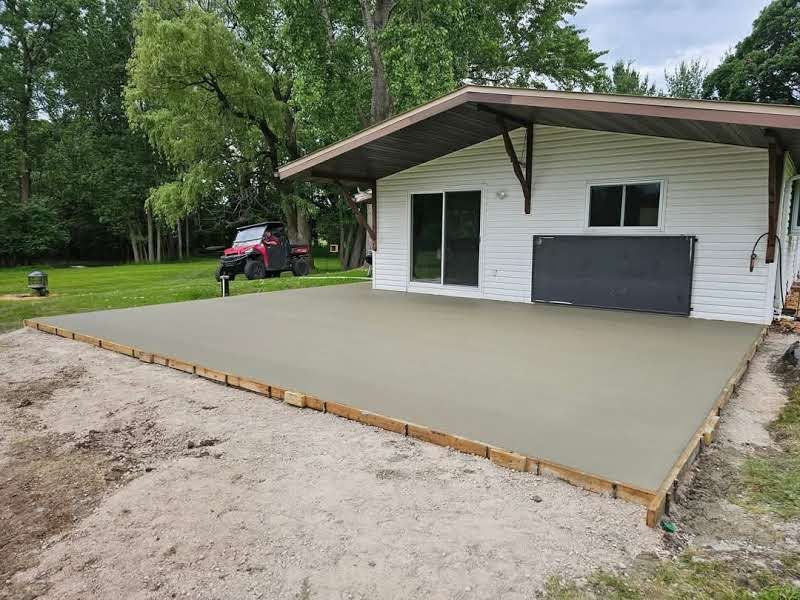 A white house with a concrete patio in front of it.