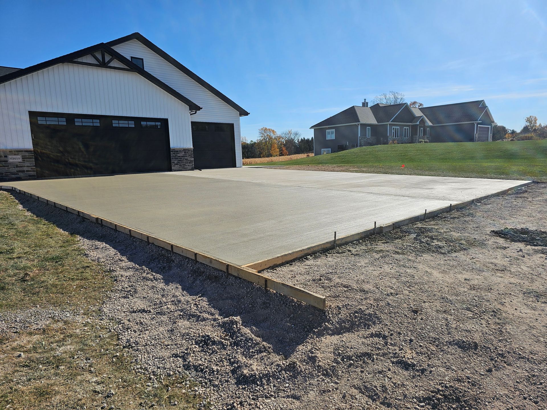 A concrete driveway is being built in front of a house.