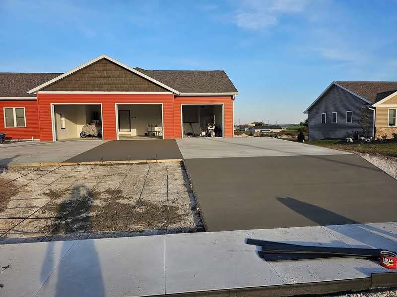A concrete driveway is being built in front of a house.