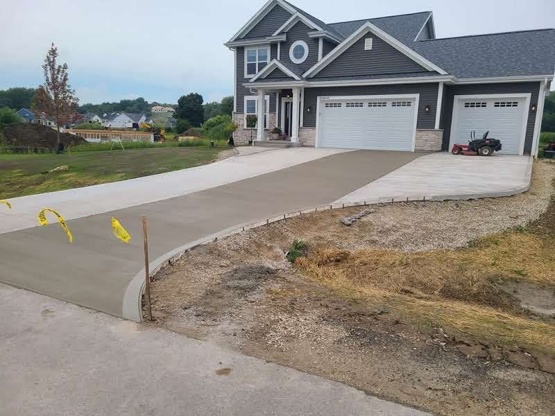 A large house with a concrete driveway in front of it.