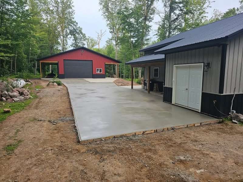 A concrete driveway leading to a garage and a house.